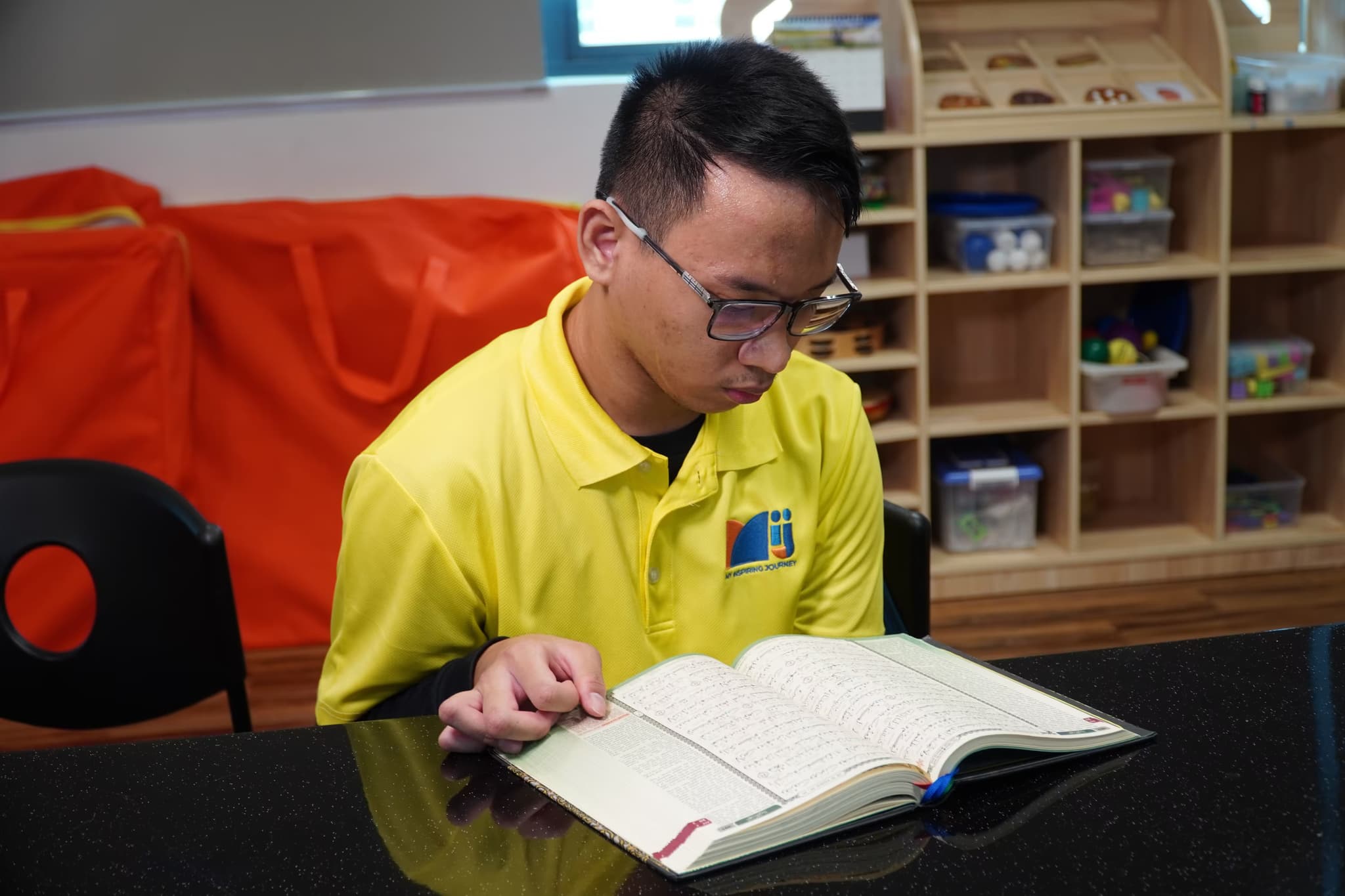 A special needs student reading the Quran